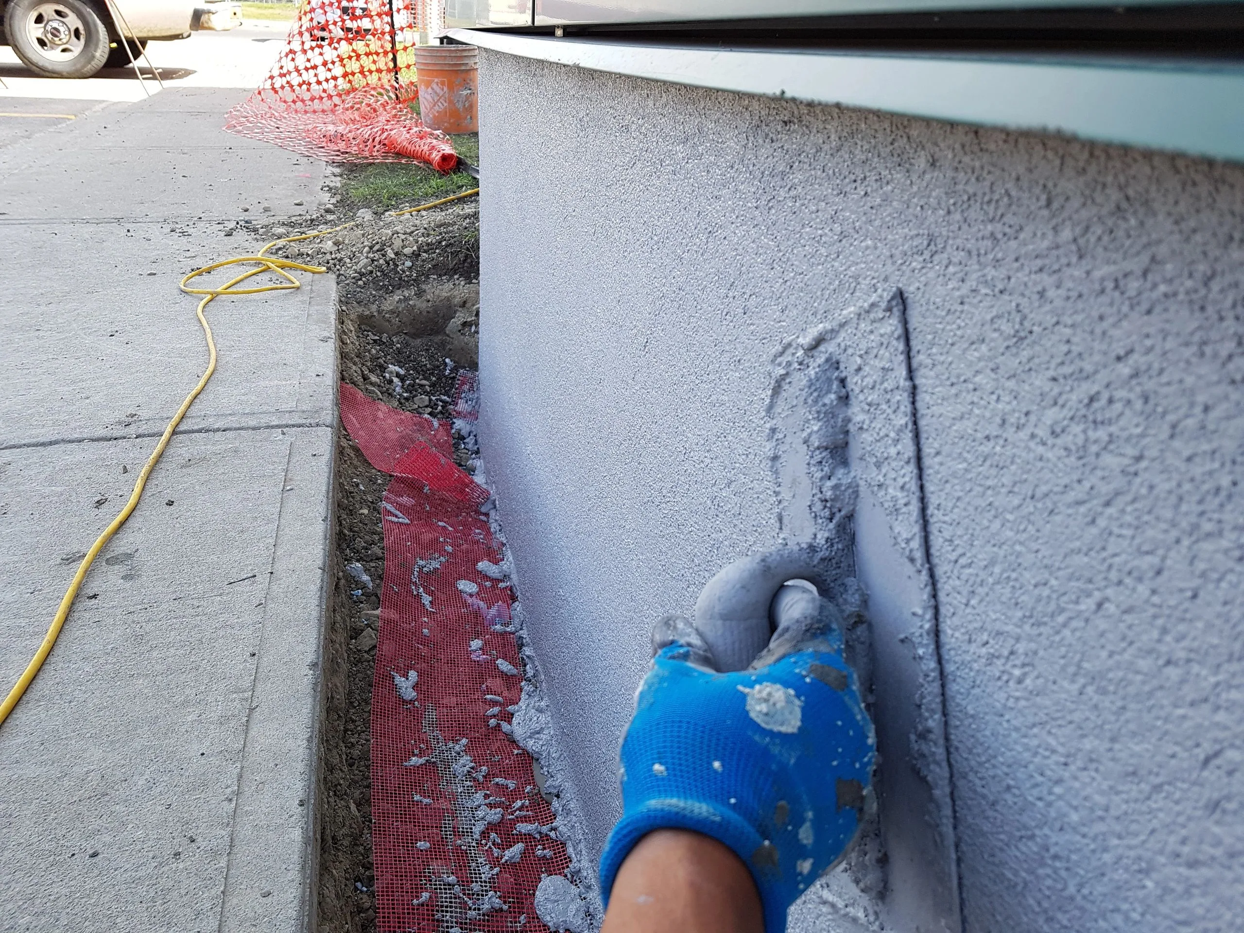 Agim Ajdini, owner of Stucco Experts, applying floated acrylic stucco over a Calgary foundation