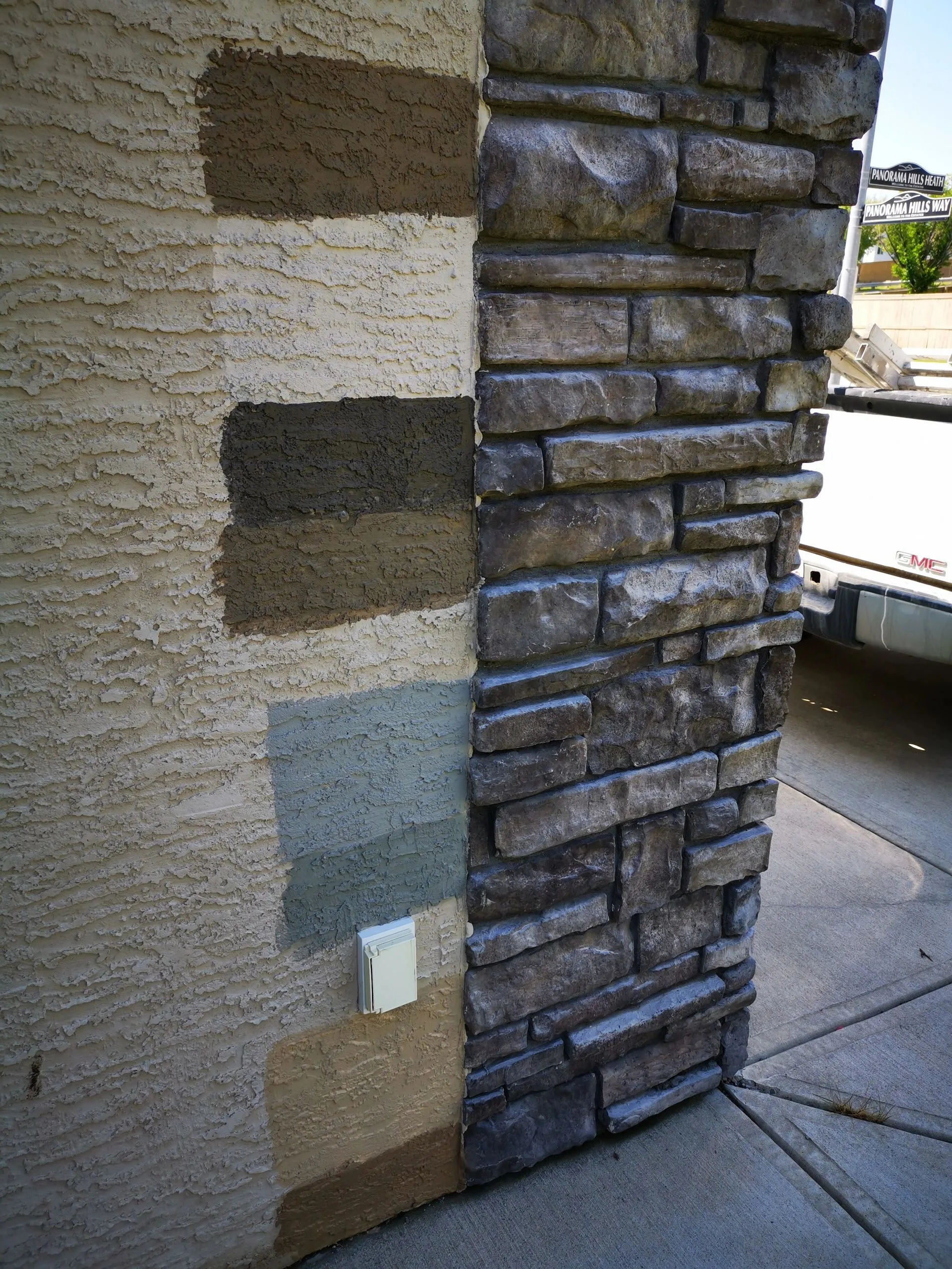 Multiple stucco paint colour samples being tested on a wall in Calgary
